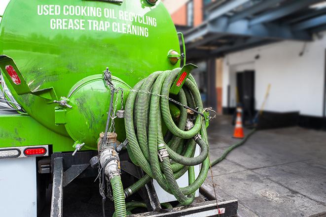 a vacuum truck pumping out a large underground grease trap in Bristol